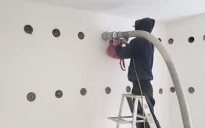 Dense-fill cellulose insulation being installed in wall cavities for soundproofing residential projects.