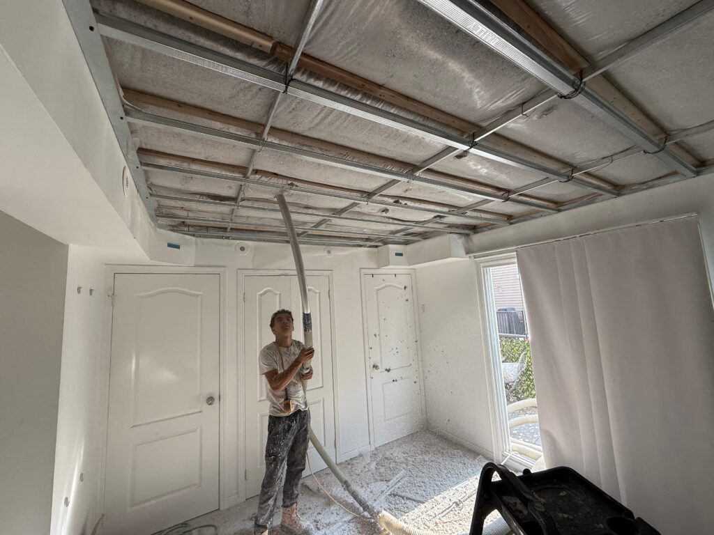 Dense-packed cellulose insulation installation in ceiling cavity, professional soundproofing process.